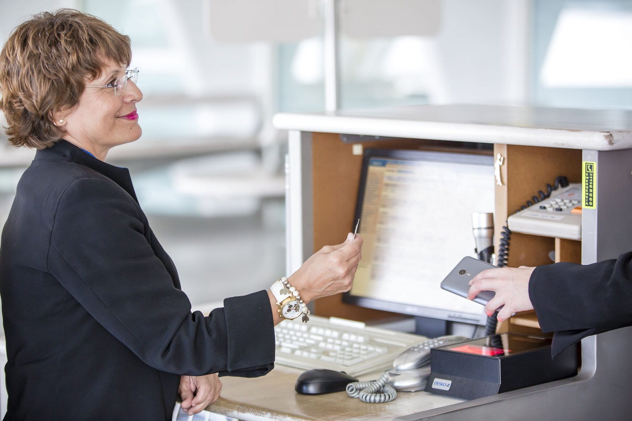 Customer service representative assisting at airport check-in counter for Globalia Corp. Travel and airline services provider.