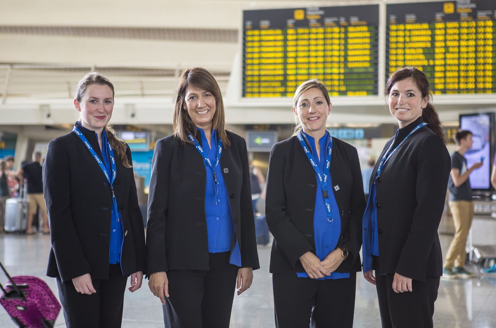 Friendly airline staff at airport check-in counter, representing Globalia Corp's aviation services.