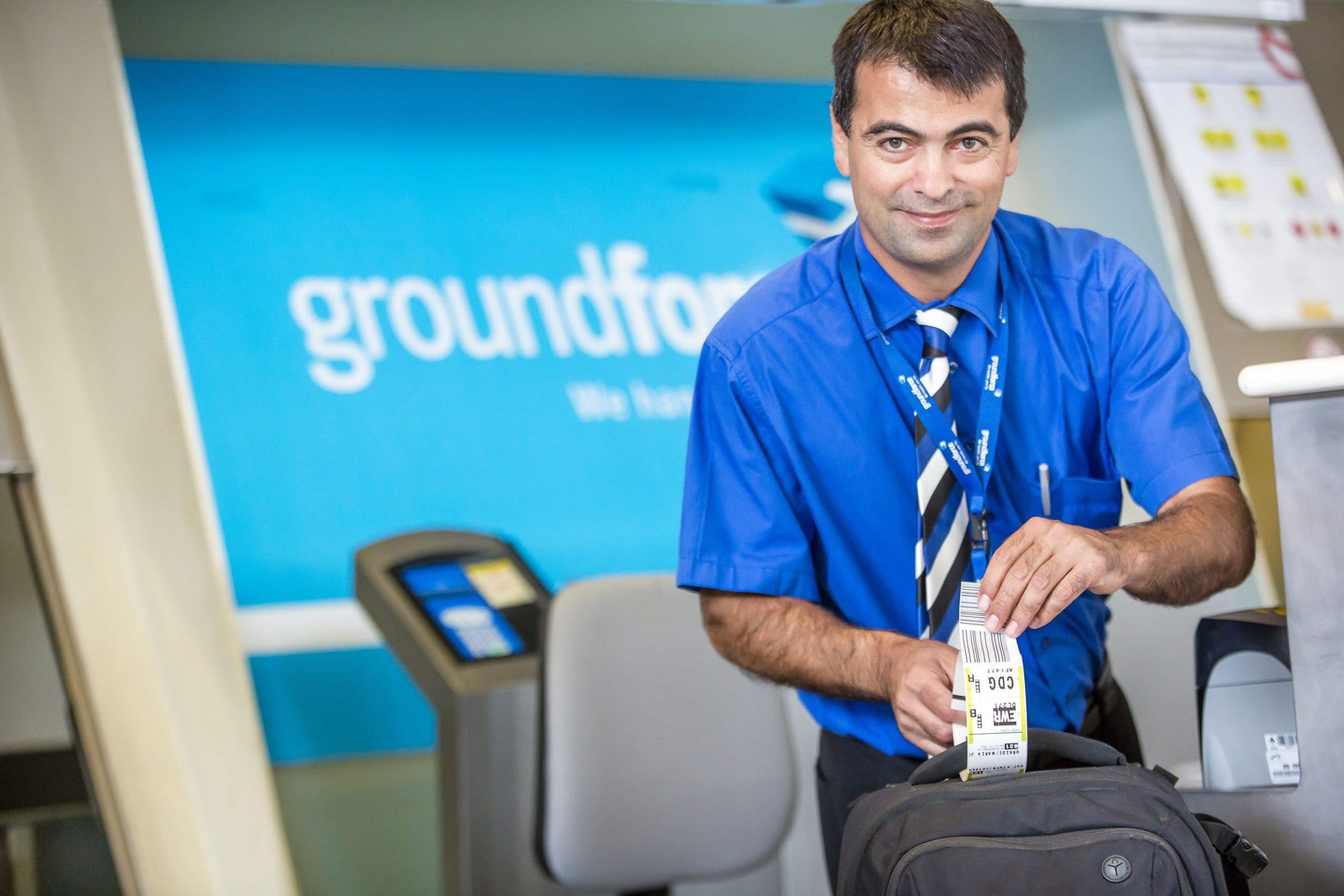 Efficient airline staff member printing boarding pass at departure counter for Globalia travel.