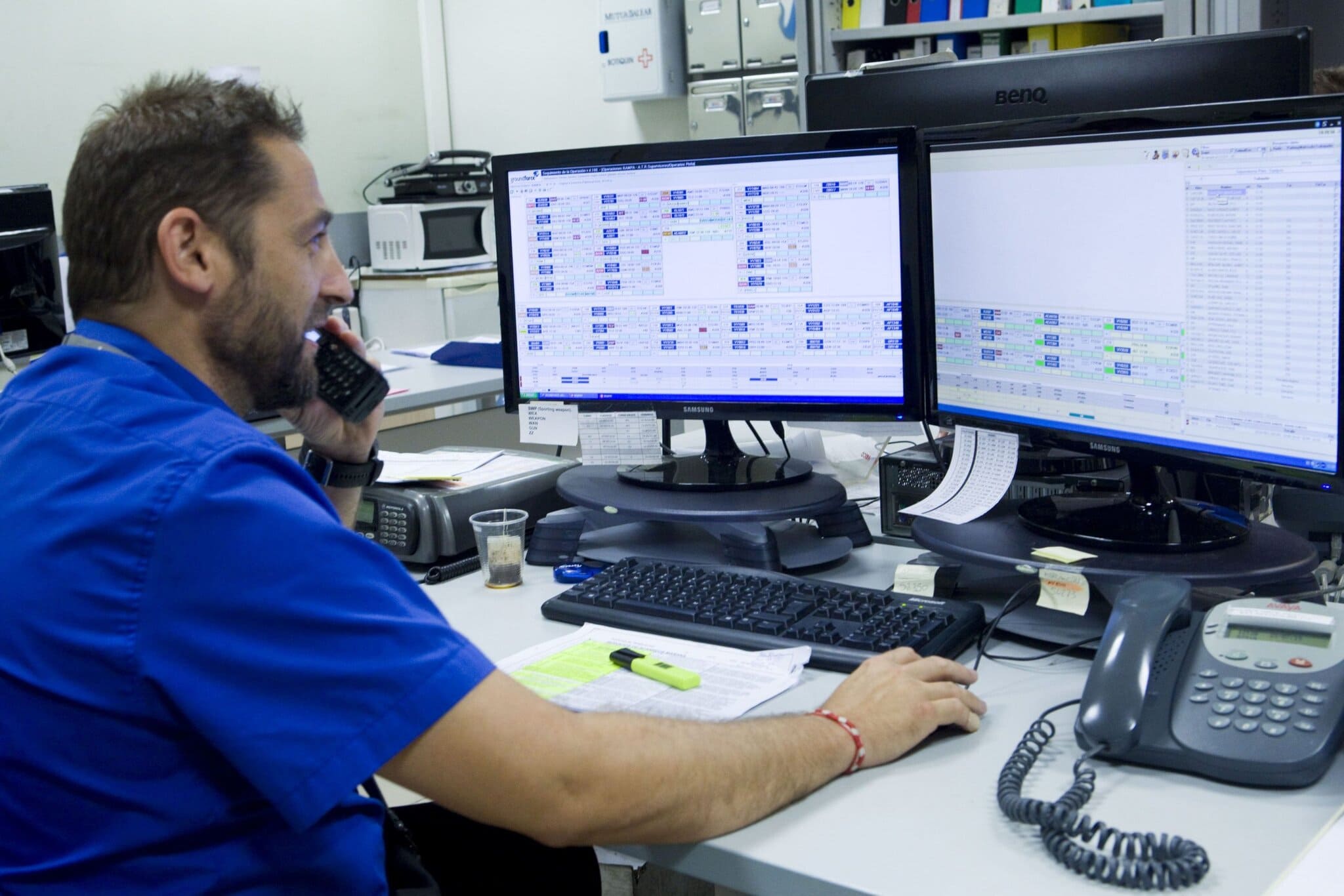 High-tech office worker managing airline schedules at Globalia Corp airline operations center.